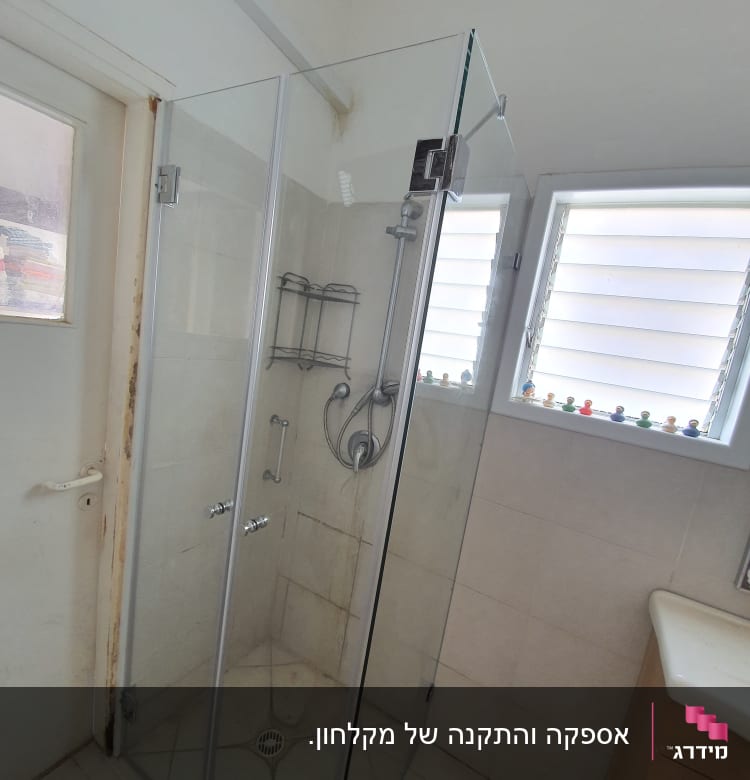 מקלחון זכוכית עם ראש מקלחת ומדף מתכת